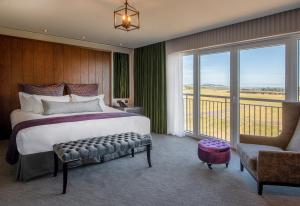 a bedroom with a large bed and a balcony at Old Course Hotel St Andrews in St. Andrews