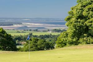 a golf course with a flag on a green at Old Course Hotel St Andrews in St. Andrews