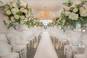a row of white chairs and tables in a room with flowers at Old Course Hotel St Andrews in St. Andrews