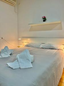 Una cama blanca con toallas en una habitación en Loft in the heart of Córdoba by gms apartamentos, en Córdoba
