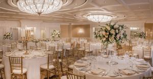 a banquet hall with white tables and chairs and chandeliers at Old Course Hotel St Andrews in St. Andrews