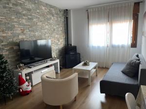 ein Wohnzimmer mit einem TV und einem Weihnachtsbaum in der Unterkunft Apartameto Verena Deluxe in Guardiola de Berga