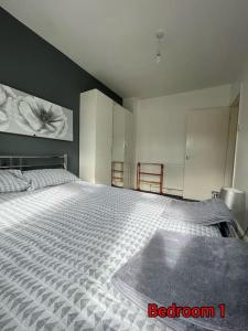 - une chambre avec un grand lit dans l'établissement Cheerful 2 bedroom mid terrace house in BD2, à Bradford