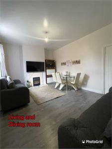 a living room with a couch and a dining room at Cheerful 2 bedroom mid terrace house in BD2 in Bradford