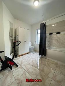 uma casa de banho com uma passadeira e uma casa de banho com um chuveiro. em Cheerful 2 bedroom mid terrace house in BD2 em Bradford