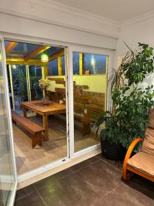 a screened in porch with a wooden table and bench at Ocean Guesthouse Baleal in Ferrel