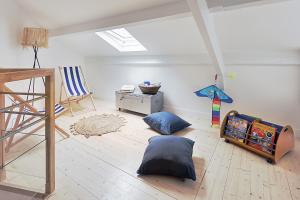 - une chambre avec un lit bébé et une table dans l'établissement La Galerie Pornic - Maison Lotus, à Pornic