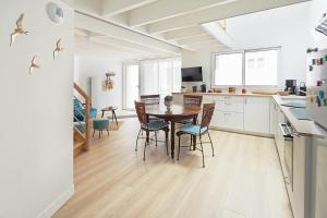 une cuisine et une salle à manger avec une table et des chaises dans l'établissement La Galerie Pornic - Maison Lotus, à Pornic