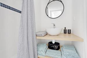 La salle de bains est pourvue d'un lavabo et d'un miroir sur une étagère. dans l'établissement La Galerie Pornic - Maison Lotus, à Pornic 12 autres photos