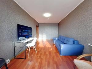 a living room with a blue couch and a table at Слава Героям 11 Сеть апартаментов Alex Apartments Бесконтактное заселение 24-7 in Poltava