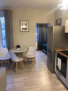 a kitchen with a table and chairs and a refrigerator at Przystanek Karpacz in Karpacz