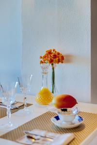 uma mesa com um vaso com flores de laranja em À dos Reis em Faro