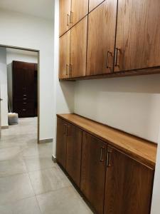 una cocina con armarios de madera y un pasillo en Best Apt Luxury Modern New 2BR Gym Pool 3mins SPGG en Monterrey