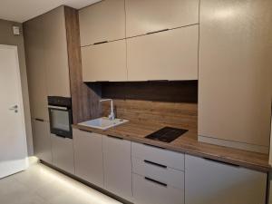 a kitchen with white cabinets and a sink at AMA by Melis in Braşov