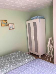 1 dormitorio con 1 cama y armario en 'het T-huisje' volledig ingerichte studio, en Lovaina