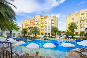 una piscina con sillas y sombrillas frente a los edificios en IL Campanario Villaggio Resort, en Florianópolis