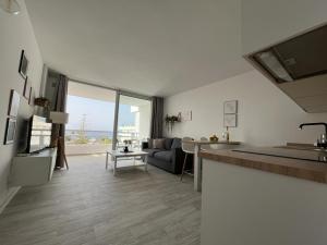 a kitchen and living room with a large window at Apart Hotel Ponderosa Tenerife in Playa de las Americas