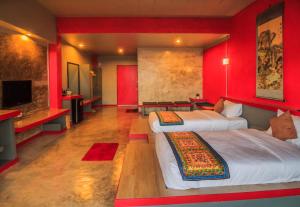 Habitación roja con 2 camas y TV en Wang Put Tan Boutique House, en Mae Salong
