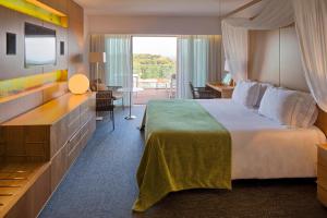 a hotel room with a large bed and a television at EPIC SANA Algarve Hotel in Albufeira