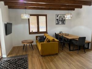 ein Wohnzimmer mit einem gelben Sofa und einem Tisch in der Unterkunft Mytho 2 in Mýto pod Ďumbierom