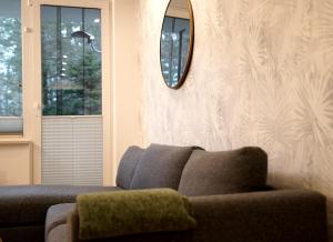 - un salon avec un canapé et un miroir dans l'établissement Apartament Okna na Park, à Polanica-Zdrój