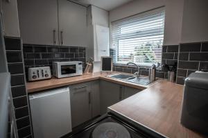 a kitchen with a sink and a microwave at Beach days 1 bed holiday home Prestatyn in Prestatyn