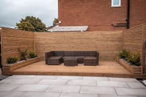 a wooden patio with a bench and a fence at Beach days 1 bed holiday home Prestatyn in Prestatyn