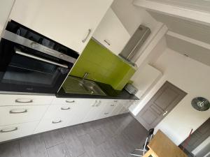 a kitchen with a sink and a stove top oven at Les Lys de Rosie - Maison familiale de plain pied campagne in Boisset-lès-Montrond