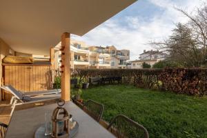 a patio with a table and a view of a building at Appartement très calme, terrasse & jardin en ville in Besançon