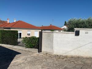a white wall with a gate in front of a house at Tony's house with private pool, garden and parking in Zadar