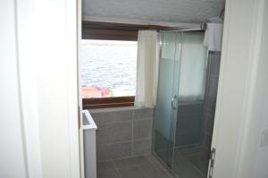 ein Bad mit Dusche und ein Fenster mit Wasser in der Unterkunft Yakamoz Otel in Urla
