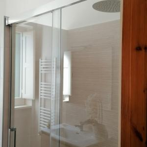a bathroom with a glass shower with a sink at Casa Marisa Villa Vacanza in Castellana Grotte