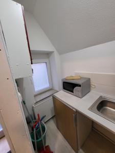 a small kitchen with a microwave and a sink at Andrei Ferienwohnung in Marktbreit