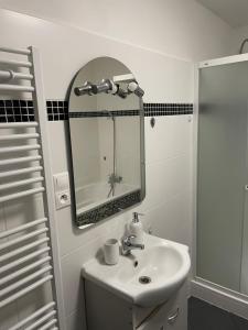 ein weißes Badezimmer mit einem Waschbecken und einem Spiegel in der Unterkunft V uličce in Velké Losiny