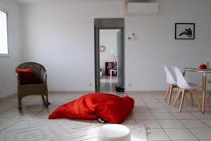 ein rotes Kissen auf dem Boden im Wohnzimmer in der Unterkunft Appartement cosy. Merville centre. Proche aéroport et Parc Exposition in Merville