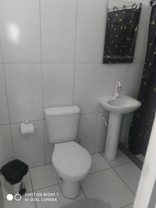 a bathroom with a toilet and a sink at Jardim Paraíso in Duque de Caxias