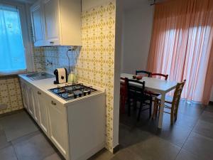a kitchen with a stove top oven next to a table at Antica Fonte holiday home in Tavullia