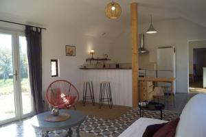 ein Wohnzimmer mit einem Tisch und einer Küche in der Unterkunft Petite longère du Clos Madeleine in Vincelles