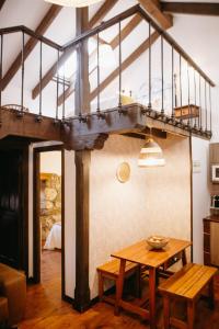 a living room with a table and a staircase at Apartamentos Rurales La Casina del Fontan in Valle de Lago
