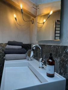 a bottle of soap sitting on a bathroom sink at Haus am Berg, Apartment 954 Hm, 82493 Klais in Krün