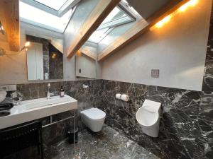 baño con lavabo y aseo y ventana en Haus am Berg, Apartment 954 Hm, 82493 Klais, en Krün