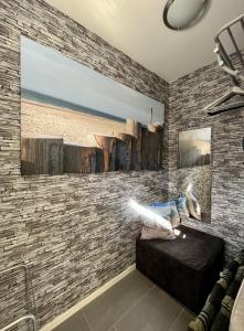 een kamer met een bakstenen muur met een bank en een schilderij bij Tussenrenesseenstrand in Renesse