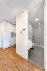uma casa de banho com armários brancos e um WC em in the MOOD no Porto