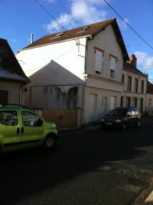 zielony samochód zaparkowany przed domem w obiekcie Atypique Studio en Duplex w mieście Châlette-sur-Loing