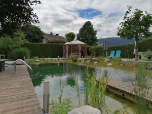 a pond with a gazebo in a yard at Garden Paradise Bled Apartments - garden, pond and castle view in Bled