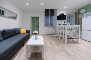 a living room with a couch and a table and a kitchen at ※Perrier Fraise※ Coeur de ville ⁕ Appt d'exception in Clermont-Ferrand