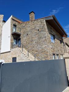 a large brick building with stairs on it at Afonsos House & Rooms in Videmonte