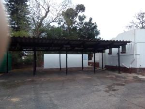 ein Parkplatz mit großem Holzdach in der Unterkunft St Lucia Villa Mia 11 in St Lucia