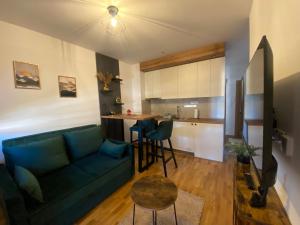 een woonkamer met een blauwe bank en een keuken bij Zlatiborika Spa&Lux Apartment in Zlatibor