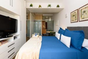 1 dormitorio con 1 cama azul grande y TV en Studio a 200m da Praia de Copacabana | FM 144/1105, en Río de Janeiro
